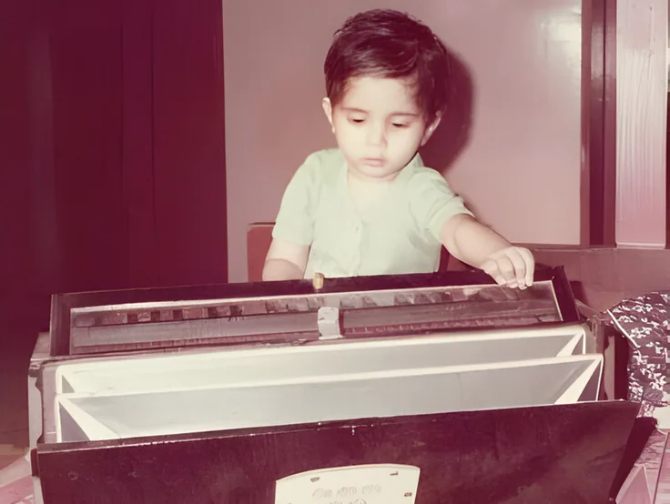 Sandeep as a toddler playing the harmonium