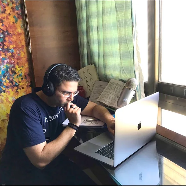 Sandeep coding on a laptop with headphones on